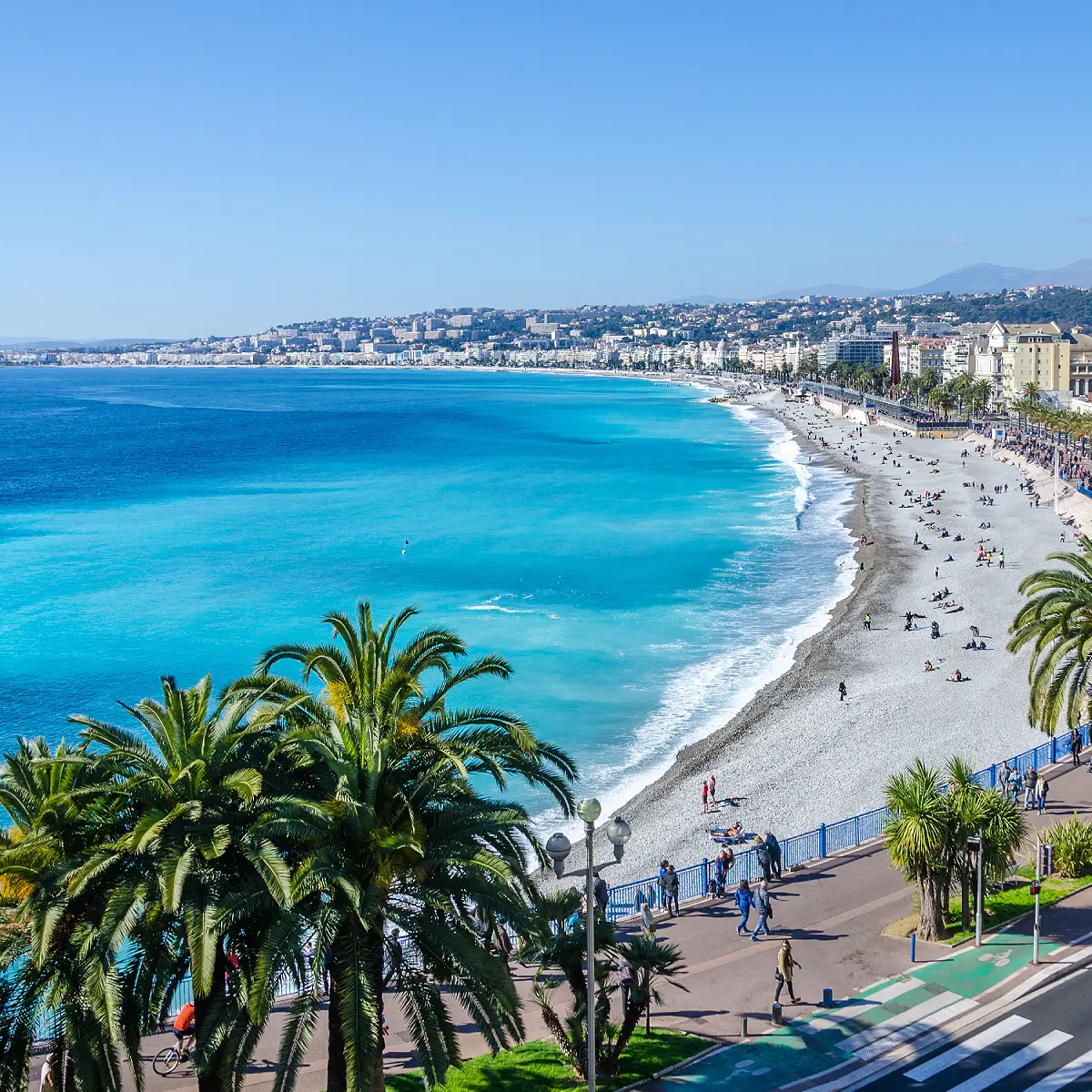 Vue sur la plage et la mer à Nice Plage avec mer turquoise et palmiers